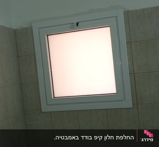 חלון אלומיניום בודד עם זכוכית חלבית בקיר אריחים
